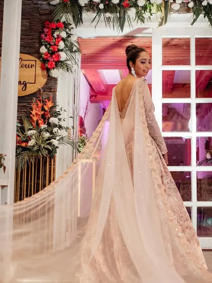 A fairytale entrance. The bride looks back as she enters her reception, her magnificent gown with a long, flowing cape creating a truly dramatic effect.