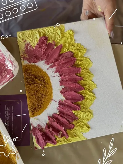 A close-up of a textured sunflower painting in progress. You can see the thick, sculpted petals created with a palette knife, adding a beautiful 3D effect to the artwork.