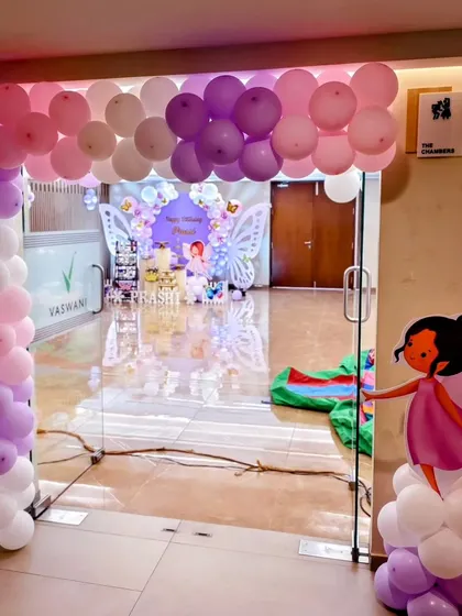 The entrance to Prashi's butterfly party, featuring a beautiful balloon arch in shades of pink and purple. A fairy cutout greets guests as they arrive.