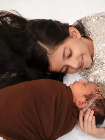The beginning of a lifelong bond. This tender moment between a big sister and her newborn sibling is what we strive to capture, the quiet, unscripted stories that define your family.