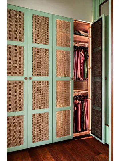 The wardrobe features integrated lighting, making it easy to see and organize clothing within the beautifully crafted space.