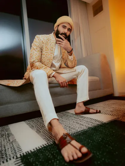 Vijay Deverakonda looking regal in a printed jacket and kurta set by Tarun Tahiliani. The yellow turban adds a traditional and vibrant finishing touch.