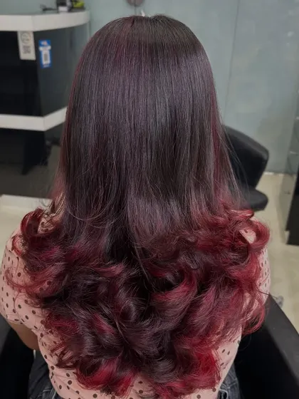For clients who want a bold yet elegant change, I love creating looks like this plum red ombre. The color melts from a natural dark base into vibrant red ends, styled with soft curls to show off the color gradient. This is a great way to express your personality.