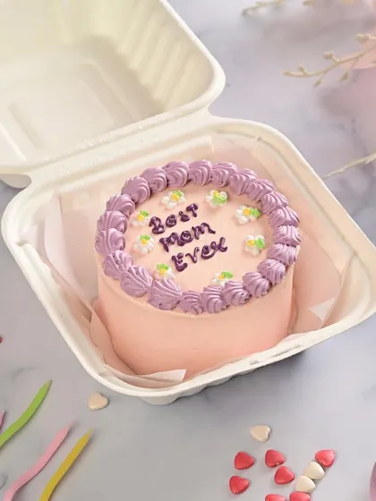 Our "Best Mom Ever" bento cake is a popular choice for Mother's Day. The simple, elegant piping and floral touches make it a lovely and personal gift.