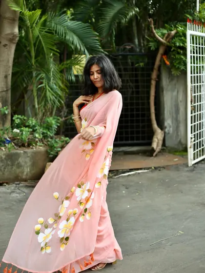 A full-length shot showing the movement and flow of the lightweight floral saree, perfect for demonstrating the garment's feel and drape.