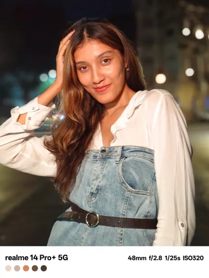 A candid feeling portrait from the night shoot. The subject's natural expression and the soft bokeh of the streetlights in the background create a relaxed and authentic city vibe.