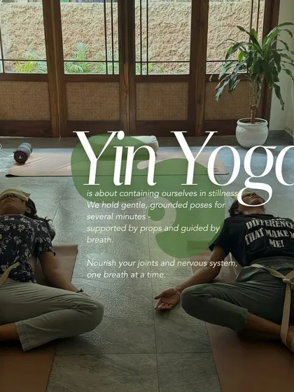 Two participants in a supported, reclined butterfly pose during a Yin Yoga class. This gentle, grounded practice uses props to help nourish the joints and calm the nervous system.