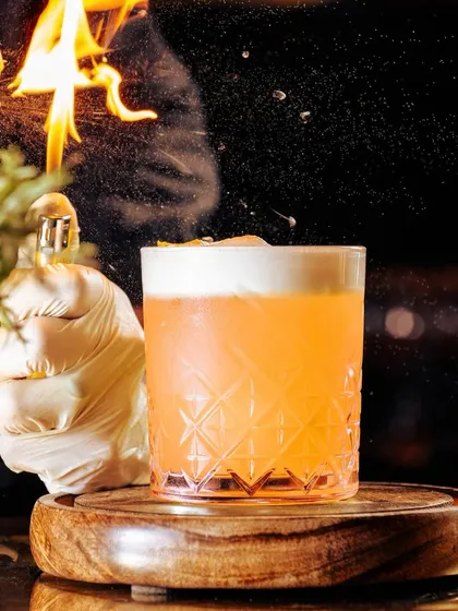 Great cocktails are about blending good flavors, beautiful presentation, and exquisite taste. Here, our bartender adds a fiery touch to a classic sour.