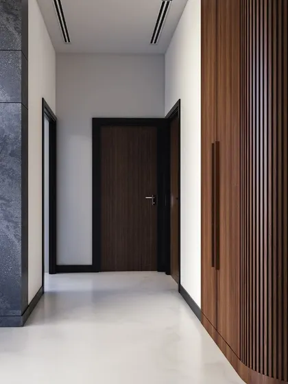 A view down the hallway, showing how the bespoke fluted wood wardrobe creates a continuous, elegant feature wall. The clean lines and rich texture elevate the entire passage.