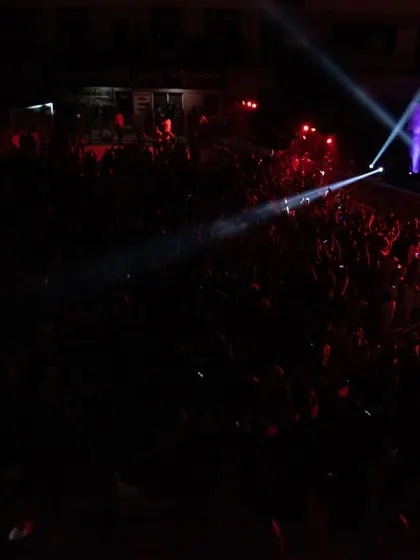 A wide shot of the massive crowd at the New Horizon College fest. The combination of stage lights and phone flashlights creates a stunning visual.