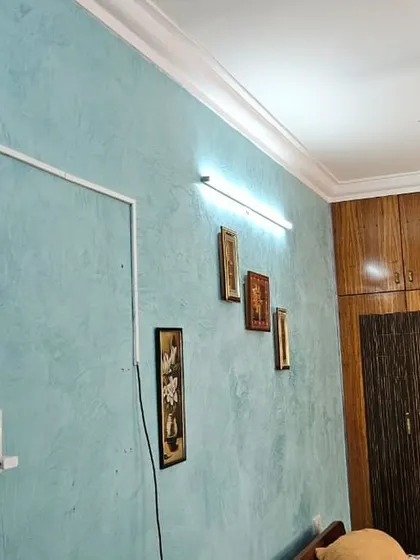 This bedroom wall features a Marble Stucco texture in a calming blue shade. The finish mimics the soft, varied look of polished marble, creating a serene and elegant atmosphere.