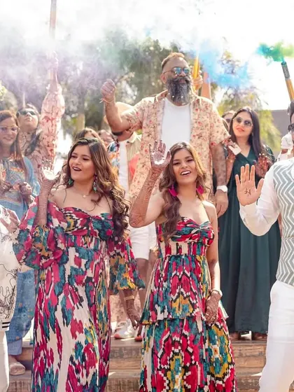 The two couples posing with color smoke bombs, adding a vibrant and dynamic element to their pool party entrance.