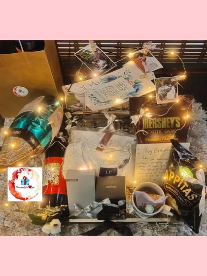 A grand hamper for the best brother. This gift is lit with fairy lights and includes a champagne bottle balloon, snacks, personalized photos, and a handwritten note.