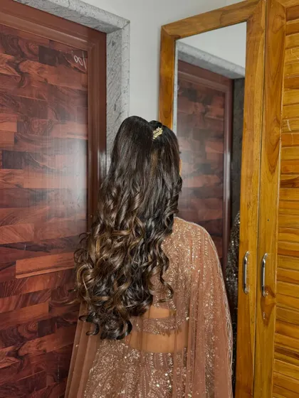 The rich brown tones of her hair and outfit create a warm and sophisticated look.
