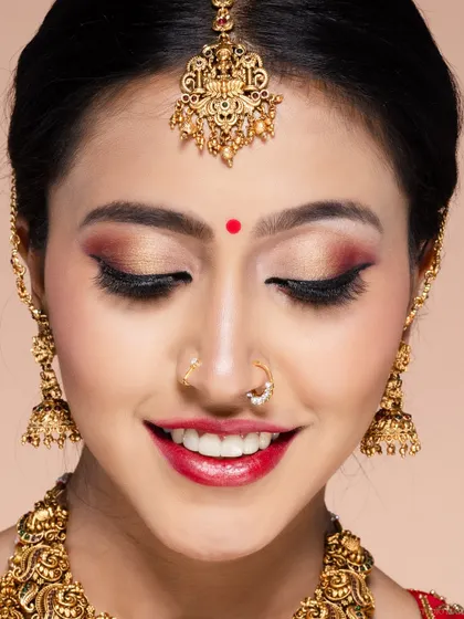 An extreme close-up on a bridal makeup look, focusing on the flawless eyeshadow, bindi, and nose ring. This level of detail is crucial for bridal beauty photography.