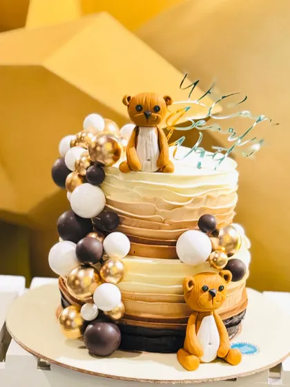 A charming teddy bear themed cake perfect for a baby shower. The ombre buttercream and cascade of chocolate spheres create a modern and sweet design.