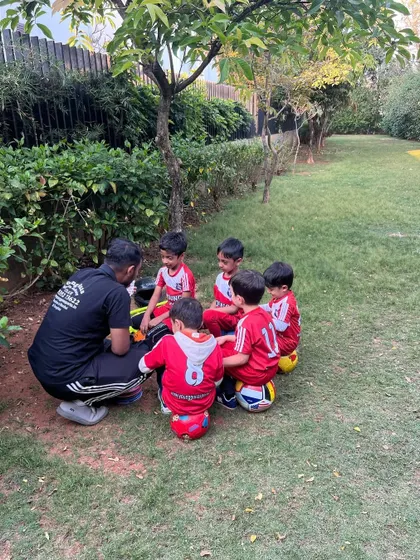 The team is gathered closely around the coach. This intimate setting allows for clear communication and helps build a strong coach-player bond.