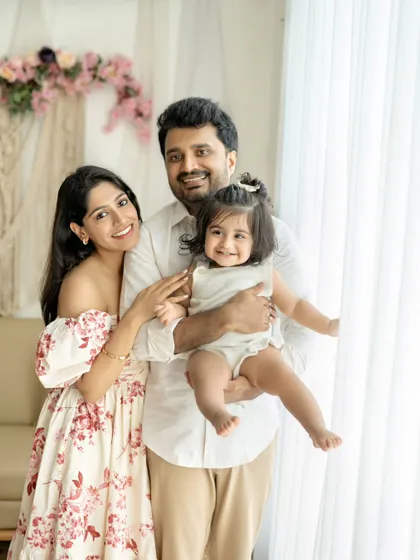 A beautiful family portrait by the window. The natural light and their happy smiles create a bright and airy feel.