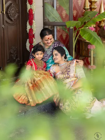 A beautiful three-generation portrait of a grandmother, mother, and daughter sharing a moment on the steps of their home.