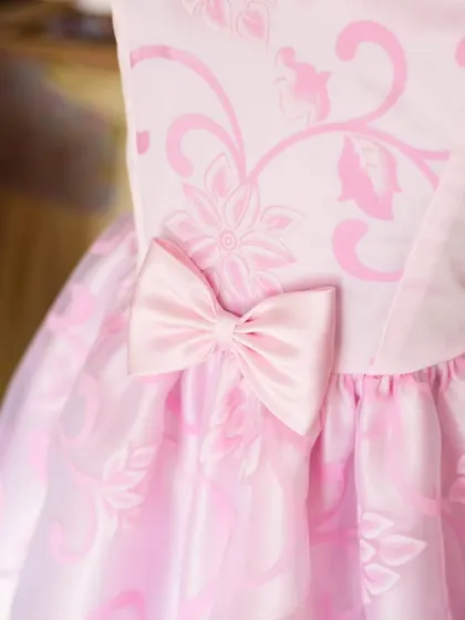 A slightly different angle of the pink bow and jacquard fabric, showing the subtle texture and sheen of the material.