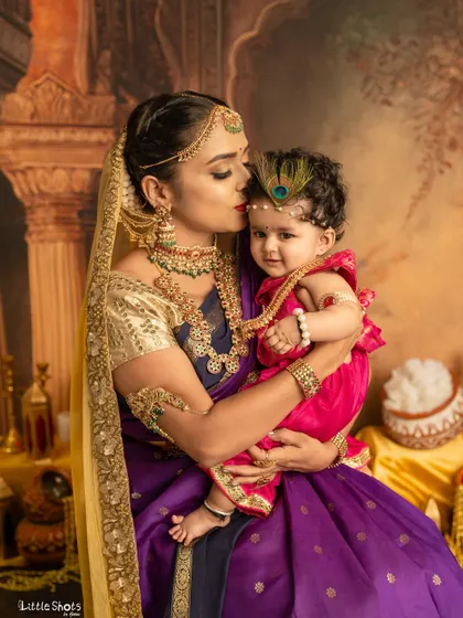 A tender kiss from mother Yashoda to her baby Krishna. This intimate moment is a beautiful expression of a mother's love, captured during our festive shoot.