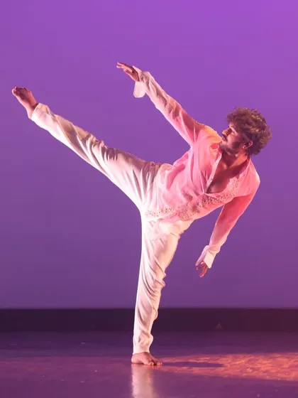 A contemporary dancer executes a high kick with precision and grace. This move demonstrates the flexibility and strength developed through our dedicated contemporary training programs.