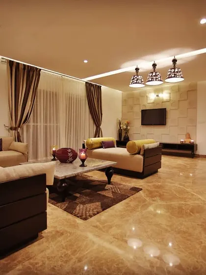 In this living room, we used handcrafted tiles to create a textured feature wall for the television. This detail adds warmth and character to the space, complementing the glossy marble floors and sophisticated furniture.