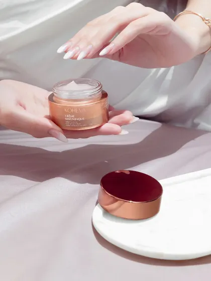 A lifestyle shot for Koheva, focusing on the texture and application of the cream. The soft lighting and gentle hand interaction create a sense of luxury, care, and self-pampering.