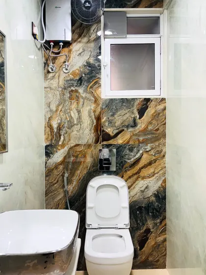 The accent wall in this bathroom uses a bold, earthy-toned tile that mimics natural stone, adding texture and a touch of drama to the space.