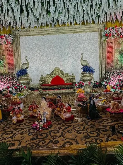 A stunning platter decoration set against a backdrop of massive floral arrangements and peacock figures.