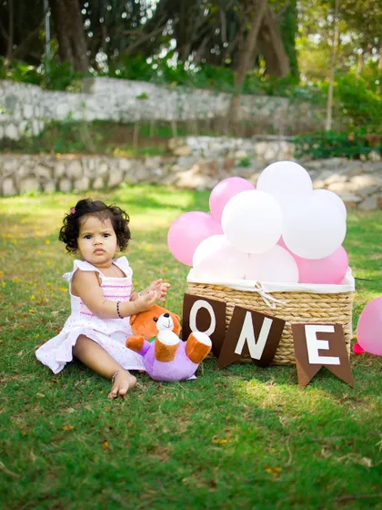 A candid moment from an outdoor first birthday session. The soft light and natural surroundings perfectly complement the simple sweetness of this milestone.