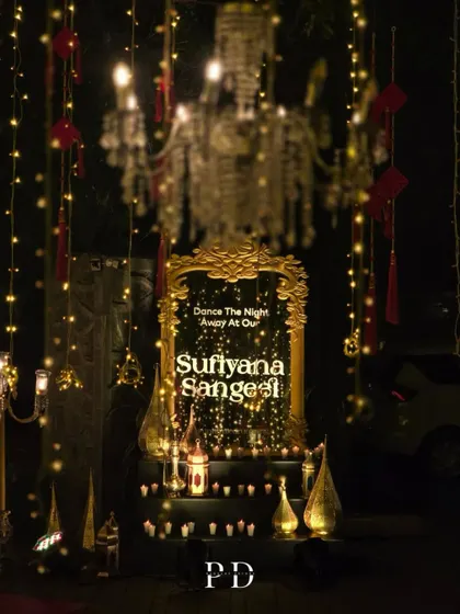 A beautiful welcome sign for a 'Sufiyana Sangeet'. The ornate gold mirror, surrounded by candles and lanterns, invites guests to 'Dance The Night Away' in style.