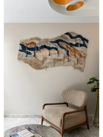 The informal sitting area on the first floor of the Slender House is simple yet elegant. A warm, neutral color scheme, carefully chosen wall art, and soft natural light from the skylight create a cozy atmosphere.