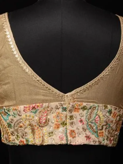 A mannequin displaying the back of the cream georgette blouse, highlighting the beautiful embroidery and sheer panel.
