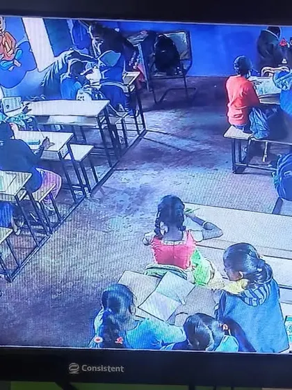 A camera captures the activity in a brightly decorated classroom.