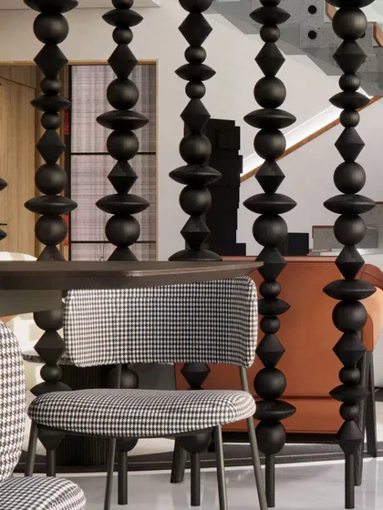 A detail of the dining area, where a screen of custom-turned wooden beads separates the space while maintaining visual connection. This element adds a layer of traditional craft to the modern design.
