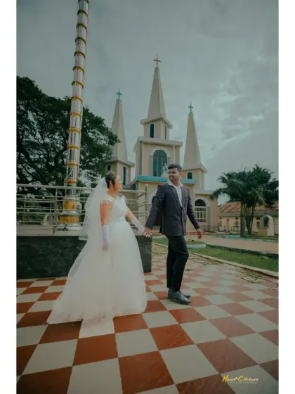 A classic Christian wedding portrait in front of the church. The bride's flowing gown and the beautiful architecture create a timeless image.