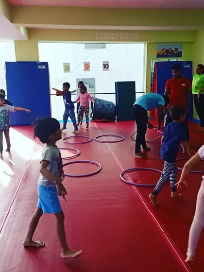 Our "Giggle Worms" enjoying a warm-up activity with hula hoops, learning about numbers and counting while they move.