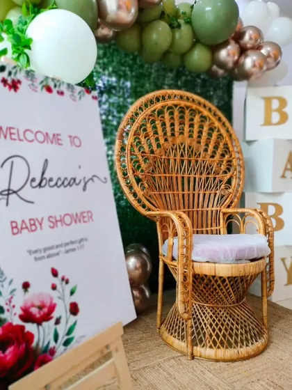 An at-home baby shower setup featuring a beautiful welcome sign and a peacock chair. I can transform any space, even your home, into a stunning celebration venue.