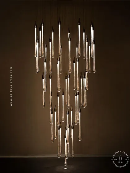 A stunning cluster of crystal teardrop pendants. Each pendant contains bubble-like inclusions that catch the light, creating a sparkling, rain-like effect. This is an elegant choice for double-height foyers or modern staircases.