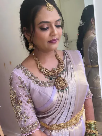 A close-up of Kavyashree's look, showing the mirror reflection and the flawless makeup.