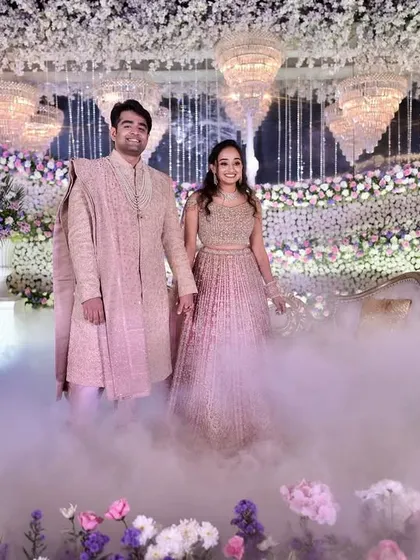 A dreamy reception entry, with the couple walking through a cloud of low-lying fog under a canopy of flowers and chandeliers.