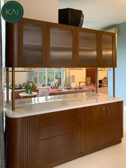 A different view of the living room bar cabinet, showing how it integrates with the overall space. The marble countertop and brass supports add a layer of luxury to this highly practical piece.