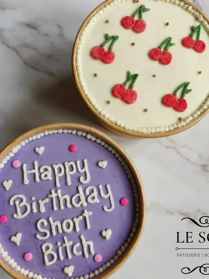 Two fun and cheeky cake tub designs. One features a cute cherry pattern, while the other has a playful "Happy Birthday Short Bitch" message for a best friend.