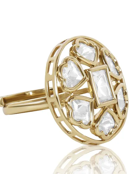 An angled shot of an intricate gold and diamond ring on a white background, focusing on the unique heart-shaped stone settings.
