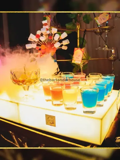 A vibrant trio of shot varieties, glowing under the bar lights and enhanced with a touch of smoke. We believe drinks should be an experience, and this is how we deliver it.