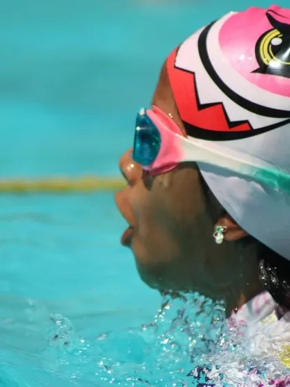 A close-up of a swimmer in action during a summer camp race. The focus and determination are clear to see.