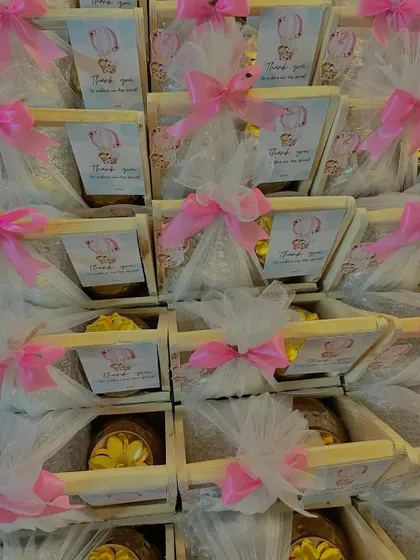 A full view of a large order of hot air balloon themed birthday favors. The consistent pink and white packaging creates a beautiful and cohesive look for the event.