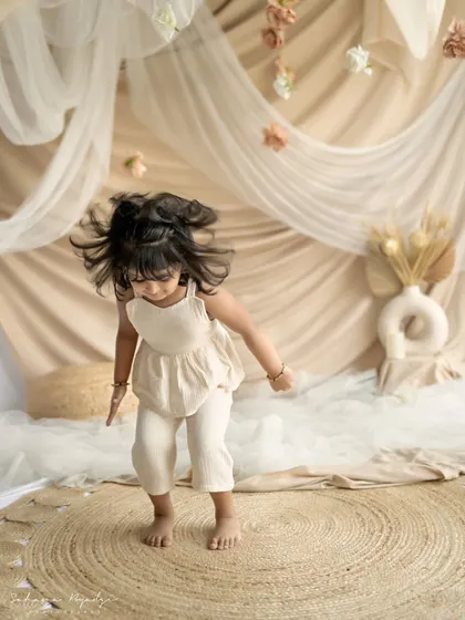 A little girl jumping for joy in the studio. This action shot perfectly captures the boundless energy and happiness of childhood.
