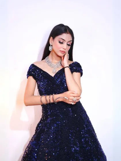A close-up of our midnight blue sequin gown, perfect for a cocktail party. The off-shoulder neckline adds a touch of classic glamour.
